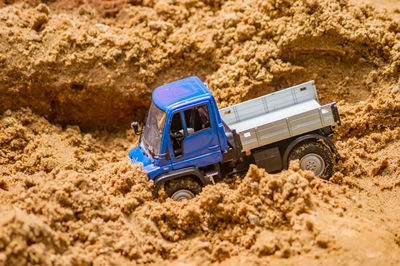 Close-up of toy truck in sand outdoors