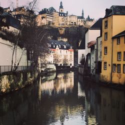 River amidst buildings in city against sky