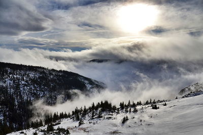 Scenic view of snow covered mountains against sky