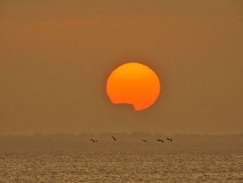 Scenic view of orange sunset sky over sea