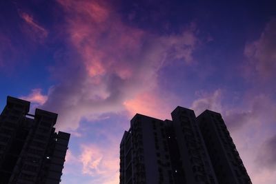 Low angle view of silhouette buildings against sky at sunset