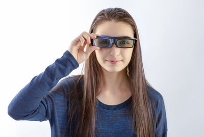 Portrait of young woman wearing eyeglasses against white background