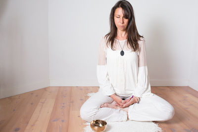 Young woman sitting on floor at home