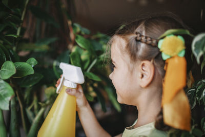 Close-up portrait of girl holding plant