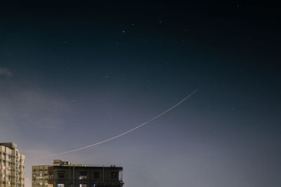 Low angle view of buildings against sky at night