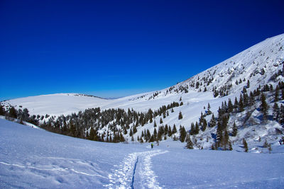 Snowcapped mountains against clear blue sky