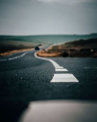 Surface level of road by sea against sky