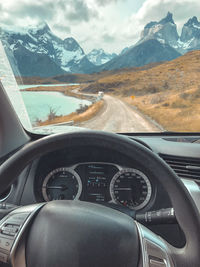 Scenic view of snowcapped mountains seen through car windshield