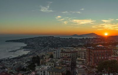 Aerial view of cityscape against sky during sunset