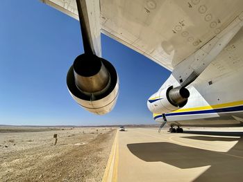Airplane on airport runway against sky, an-124