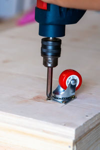 Close-up of red castor wheel on table