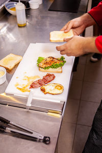 Cropped hand of person preparing food on table