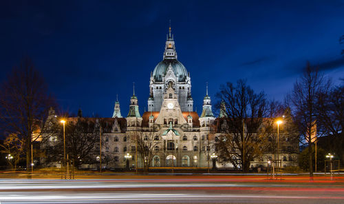 Light trails by new town hall against sky at night