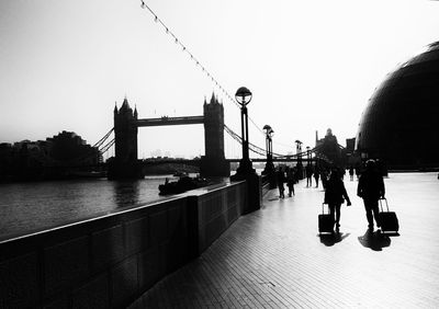 People on suspension bridge over river