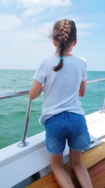 Rear view of man on boat sailing in sea against sky