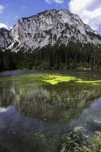 Scenic view of lake by mountains against sky