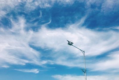 Low angle view of silhouette street light against sky