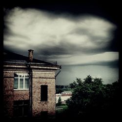 Houses against cloudy sky