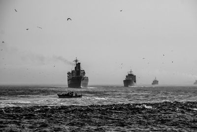 Ships sailing in sea against clear sky