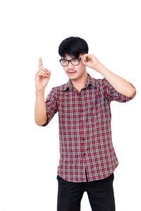 Portrait of young man standing against white background