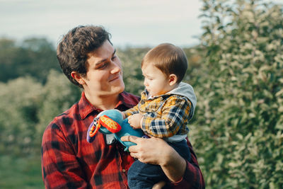 Father holding son while standing in park