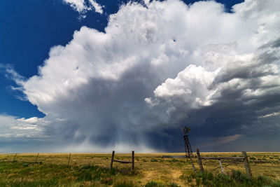 Scenic view of field against cloudy sky