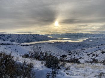 Scenic view of snow covered mountains against sky during sunset