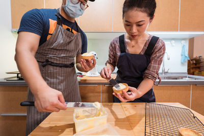 Mid adult woman having food at home