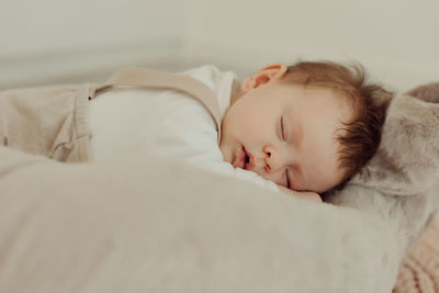 Cute baby girl sleeping on bed at home
