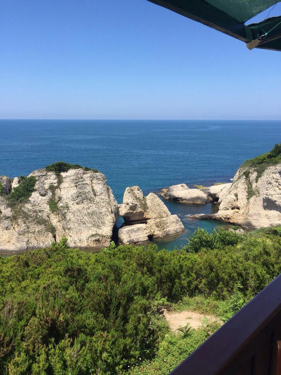 clear sky, horizon over water, sea, copy space, tranquil scene, water, scenics, tranquility, blue, rock - object, beauty in nature, nature, rock formation, rock, cliff, idyllic, day, landscape, sunlight, high angle view