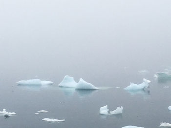 Close-up of frozen water against sky