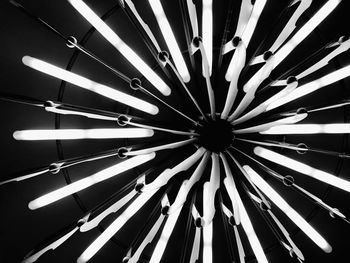 Low angle view of illuminated lighting equipment against ceiling