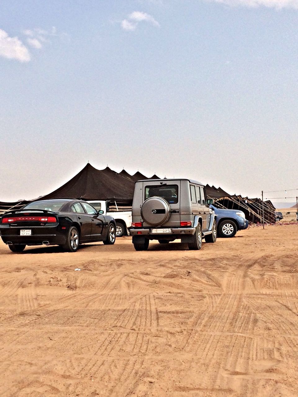 transportation, land vehicle, mode of transport, car, sky, travel, stationary, landscape, road, day, outdoors, clear sky, desert, street, sunlight, vehicle, no people, on the move, parked, parking