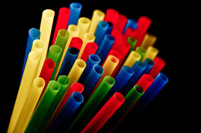 Close-up of colorful colored pencils over black background