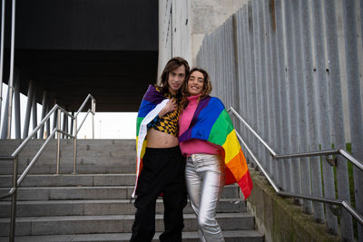 Portrait of young woman standing against wall