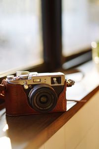 Close-up of vintage camera on window sill