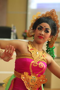 Woman in traditional clothing practicing dance in room