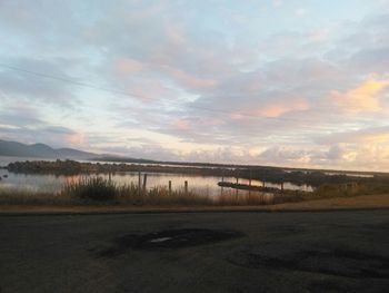 Scenic view of sea against cloudy sky at sunset