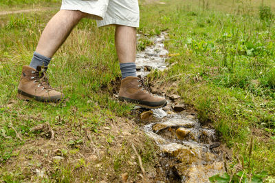 Low section of person wearing shoes on field