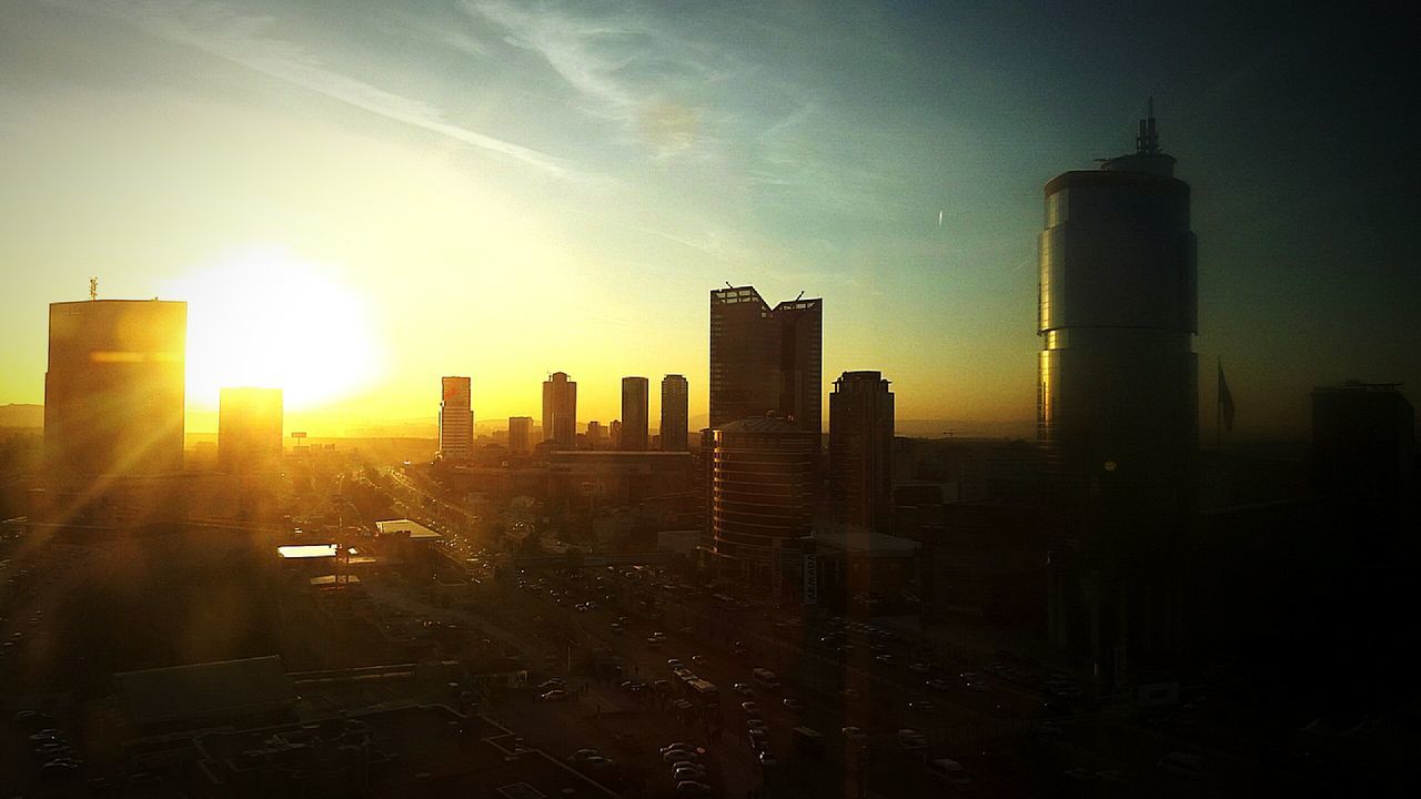 sunset, building exterior, architecture, sun, built structure, city, skyscraper, tower, sky, sunlight, sunbeam, silhouette, tall - high, lens flare, cityscape, urban skyline, office building, orange color, building, modern