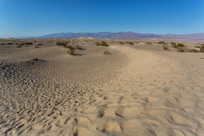 Scenic view of desert against clear blue sky