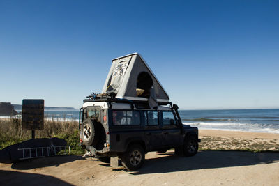 Vintage car on beach against clear sky