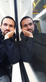 Portrait of man with reflection on window