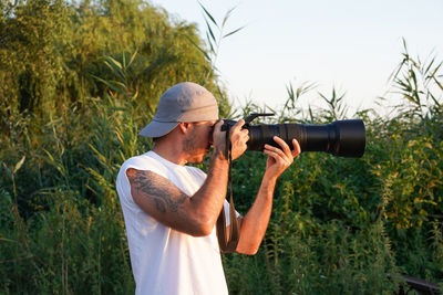 Man photographing while standing on field