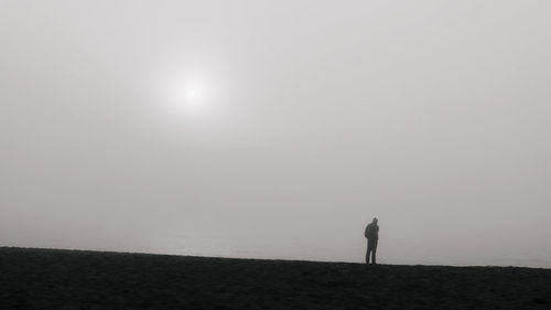 Silhouette of man standing on field