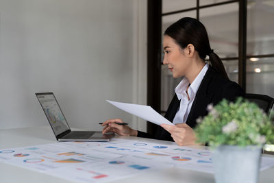 Businesswoman using laptop on table