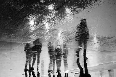 People walking on wet road during rainy season