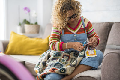 Midsection of woman sitting on sofa