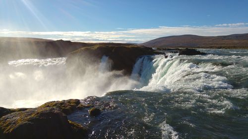 Panoramic view of waves breaking against sea