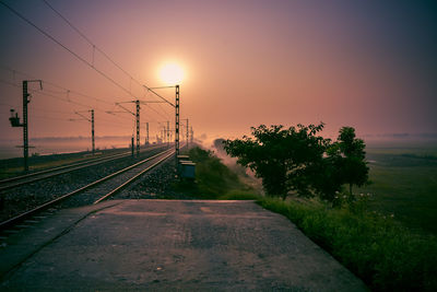 Railroad tracks against sky during sunset